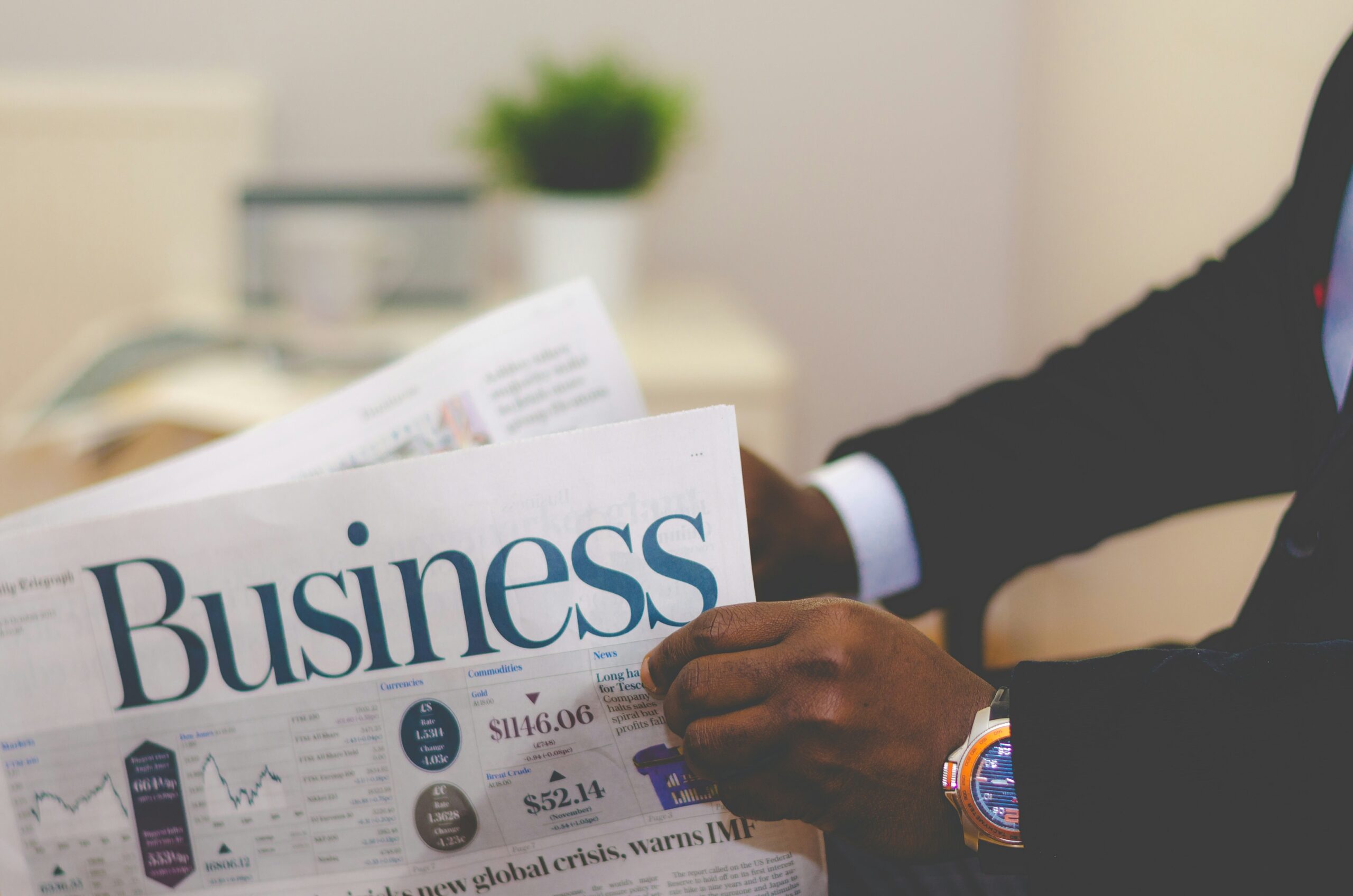 a man wearing a suit reading a business newspaper | Automating and securing the compensation review process for mid-sized businesses