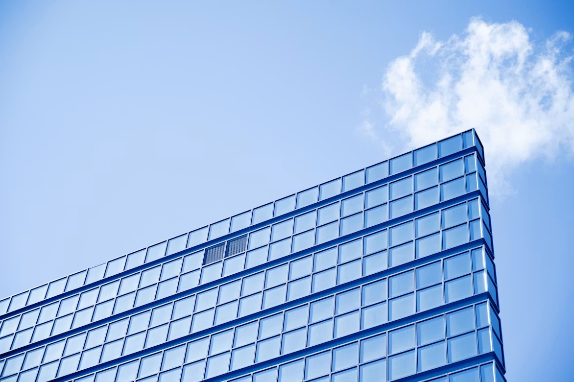 Modern glass office building against a blue sky, representing SAP Cloud ERP Public modernization for APAC organisations.