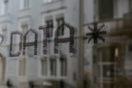 Dot-matrix lettering spelling the word DATA with an asterisk on a glass window reflecting a city building, representing the SNP Kyano platform theme of preparing the best data for business AI in SAP transformations.