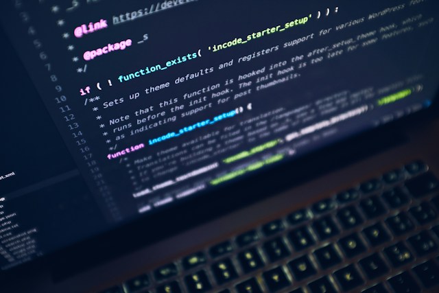 Close-up of a laptop screen displaying source code in a dark code editor, representing custom code analysis and clean-core assessment within SNP Kyano for SAP and non-SAP transformation programmes